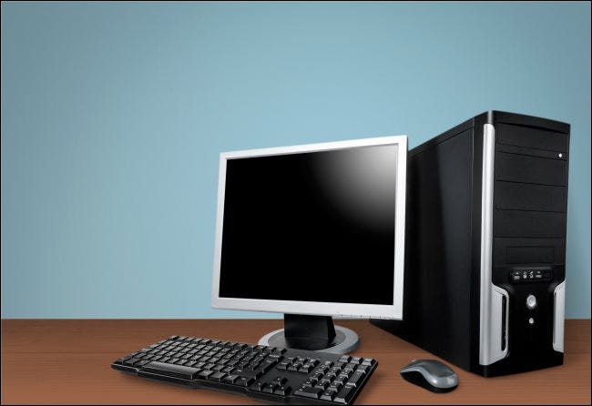 Un boîtier d'ordinateur de bureau, un moniteur, un clavier et une souris sur une table.
