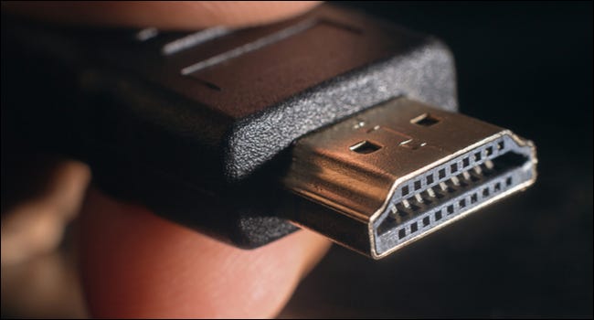 Libre d'un connecteur HDMI entre les doigts d'une personne.