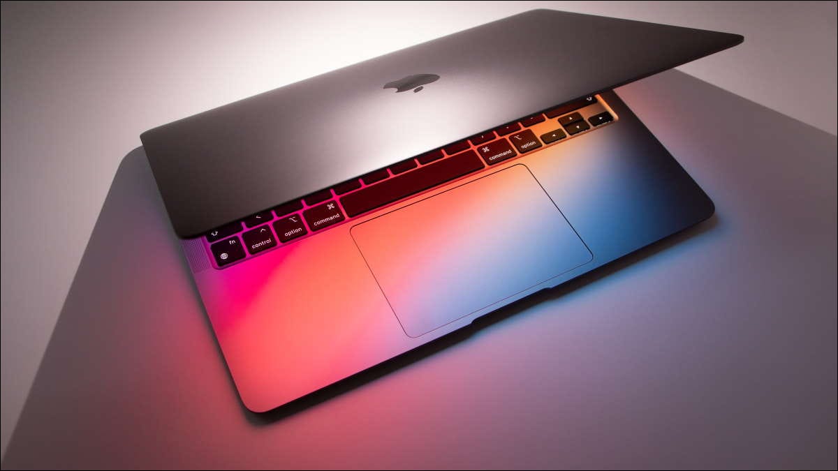 macbook légèrement ouvert pour éclairer le clavier et la table