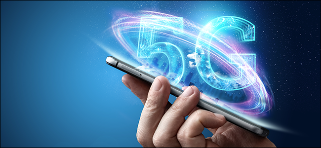 Une main tient un iPhone avec un hologramme qui dit "5G "flottant hors du téléphone.